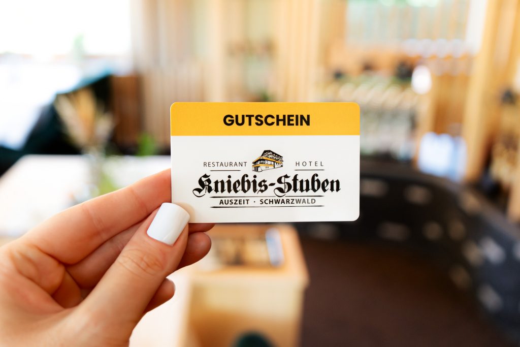 Dame hält Restaurant-Gutschein in der Hand.